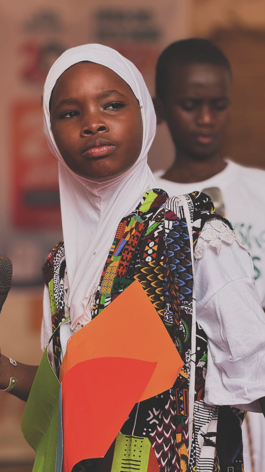 Élève en tenue wax colorée tenant une carte de l’Afrique – Fête de fin d’année